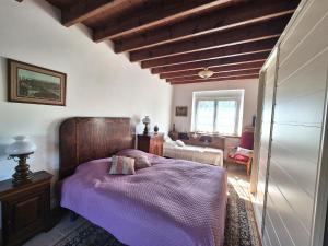 een slaapkamer met een paars bed met een houten hoofdeinde bij Spacious Family Home Near the Sea in Denneville