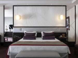 a bedroom with a large bed with purple pillows at Sofitel Beirut Le Gabriel in Beirut