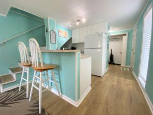 a kitchen with two stools and a refrigerator at 423 Sea Cloud in Edisto Island