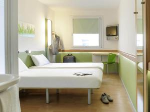 a hospital room with a couch and a sink at ibis budget Hamburg Altona in Hamburg