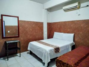 a hotel room with a bed and a mirror at Hotel Azulhito in Tampico