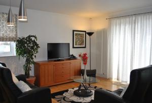 a living room with a tv and a couch and a table at Dreamhouse Apartments Edinburgh Holyrood Park in Edinburgh