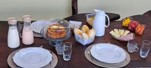 a wooden table topped with plates and bowls of food at Pousada Sol de Berlinque in Vera Cruz de Itaparica