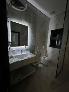 a bathroom with a sink and a toilet at غرفة ببانيو مع صالة 9 من أرام ريزدنس by ARAM Residence in Aţ Ţuwayr