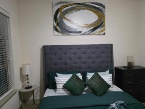 リチャードソンにあるOur Cozy homeのベッドルーム1室(緑と白の枕が備わるベッド1台付)