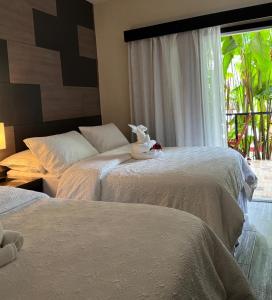 ein Schlafzimmer mit zwei Betten und einem Fenster in der Unterkunft Refugio Huasteco Hotel Boutique in Tamasopo + 38 Fotos