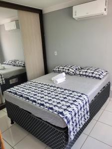Un dormitorio con dos camas y un espejo. en Apartamento confortável com ar condicionado, en Montes Claros