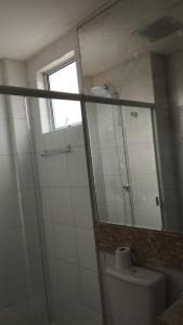 a bathroom with a mirror and a toilet and a window at Aconchego in Porto Belo +12 photos