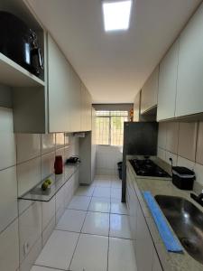 Una gran cocina blanca con fregadero y estufa. en Apartamento confortável com ar condicionado, en Montes Claros 5 fotos más