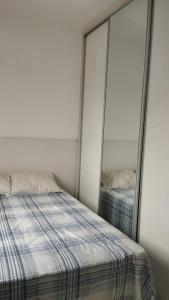 a bedroom with a bed and a mirror at Aconchego in Porto Belo