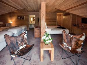 a hotel room with two beds and two chairs at Mercure Saint-Lary in Saint-Lary-Soulan