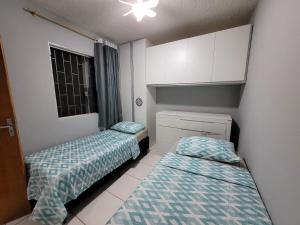 Una habitación con dos camas y una ventana. en Apartamento confortável com ar condicionado, en Montes Claros