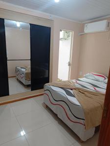 a bedroom with a bed and a large mirror at Apart hotel - 2 tranquilidade e conforto de casa in Tuparendi