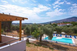 a villa with a swimming pool and mountains in the background at Petra Natura in Limenaria