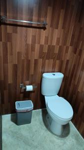 a toilet in a bathroom with a wooden wall at Mentari in Gili Gede