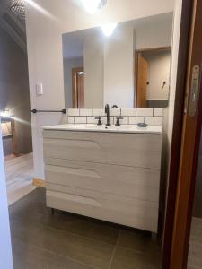 een badkamer met een wastafel en een grote spiegel bij Black Hills Caviahue in Caviahue +36 foto's