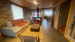 a living room with a couch and a stone wall at Black Hills Caviahue in Caviahue