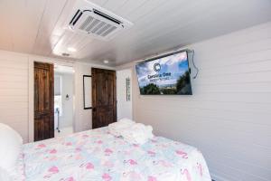 Habitación con cama y pantalla en la pared en Marysol Cottage, en Edisto Beach