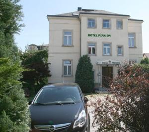 un coche aparcado frente a un edificio en Hotel Pension Kaden, en Dresden