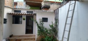an outside view of a white building with a ladder at Kitnet Encanto Astral in São Thomé das Letras