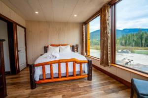 ブルーリバーにあるRiver Safari Lodgeのベッドと大きな窓のある寝室