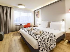 a hotel room with a bed and a chair at Mercure Marseille Centre Prado Vélodrome in Marseille