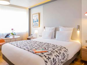 a hotel room with a bed with a book on it at Mercure Marseille Centre Prado Vélodrome in Marseille +53 photos