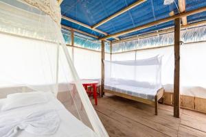 a bedroom with two beds and a mosquito net at Red Uakari Jungle Lodge in Iquitos