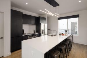 a kitchen with a white counter top and black cabinets at Beverly - Private Patios - Jacuzzi - In Old Town in Scottsdale