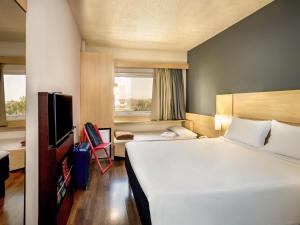 a hotel room with a large bed and a television at ibis Paulinia in Paulínia