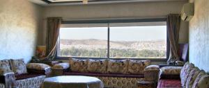 a living room with a couch and a large window at City Center Residency With Panoramic City Views - 2 Min Train Station by ZenStay in Fès