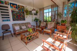 Rio Uruguai Pousada في أوروغويانا: غرفة معيشة مع أريكة وطاولات وكراسي
