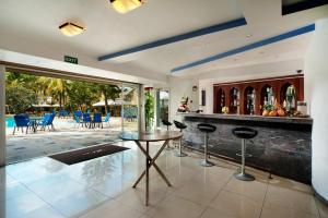a kitchen with a bar with chairs and a pool at Manisa Hotel in Flic-en-Flac