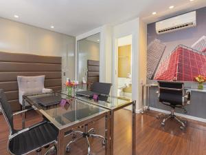a salon with a glass desk and two chairs at Mercure Sao Paulo Vila Olimpia in Sao Paulo +132 photos