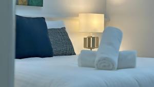 a bedroom with a white bed with a lamp at Plover Executive Deluxe Villa 25 in Cams Wharf