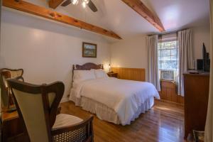 a bedroom with a white bed and a window at Moore House Inn & Cabins in Marlinton