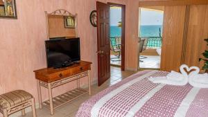Un dormitorio con una cama y un televisor y un balcón. en Sonoran Spa W403, en Campo del Medio