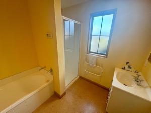 Un baño con bañera, lavabo y bañera. en 30 St James Avenue, en Hanmer Springs 10 fotos más