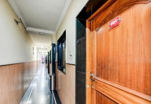 a hallway with a exit sign on a wooden door at Hotel O Rourkela Palace in Raghunāthpāli