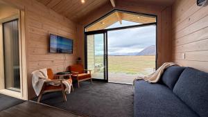 Una sala de estar con un sofá y un televisor y una ventana. en Sleep under the stars at Manuka Starlight, en Twizel