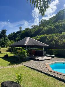 a house with a swimming pool and a pavilion at Luna's Home Raiatea in Tiano