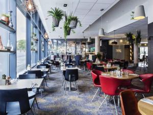 a restaurant with tables and chairs in a room at Novotel Edinburgh Centre in Edinburgh