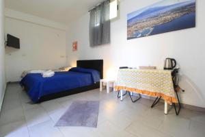 a bedroom with a bed and a table in it at BED&FLY NEAR AIRPORT CATANIA FONTANAROSSA BAGNO PRIVATO In CAMERA in Catania