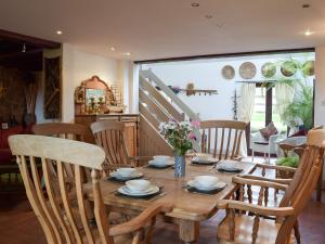 ein Esszimmer mit einem Holztisch und Stühlen in der Unterkunft Sardis Cottage in Stepaside + 10 Fotos