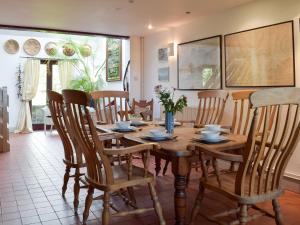 ein Esszimmer mit einem Holztisch und Stühlen in der Unterkunft Sardis Cottage in Stepaside