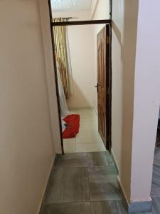 a hallway with an open door and a red rug at Mango Plaza in Homa Bay