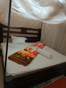 a bed in a tent with a blanket on it at Mango Plaza in Homa Bay