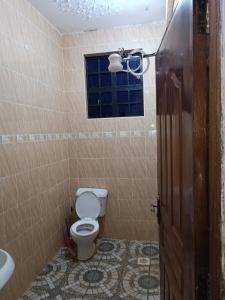 a bathroom with a toilet and a window at Mango Plaza in Homa Bay
