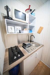 a small kitchen with a stove and a sink at Studio Soleil Couchant in Pointe-Noire