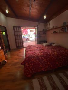 a bedroom with a bed with a red comforter at Casa Principal in Itapeva